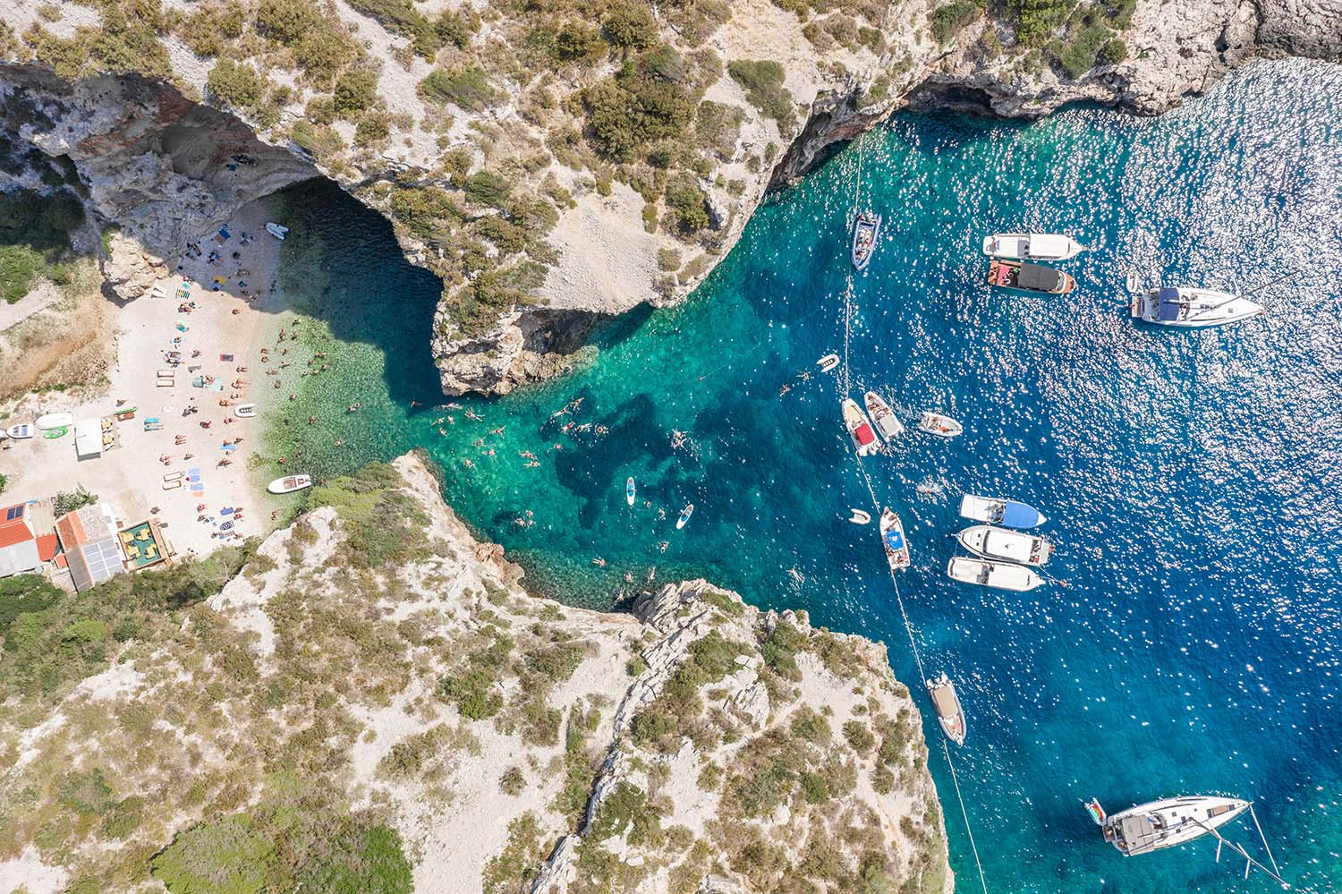 Aerial overhead drone shot of yachts at Stiniva cove Adriatic sea on Vis Island in Croatia summer
